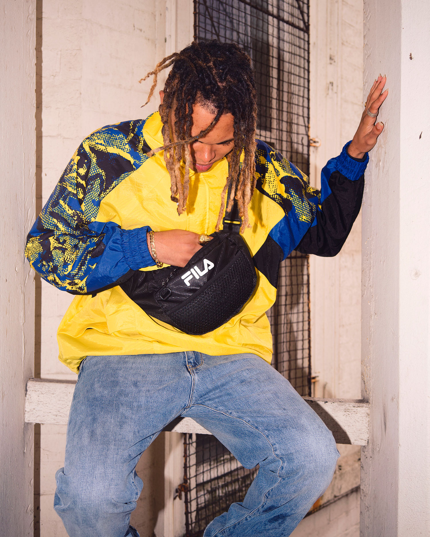 A man wearing a blue and yellow FILA Apparel Pullover Jacket