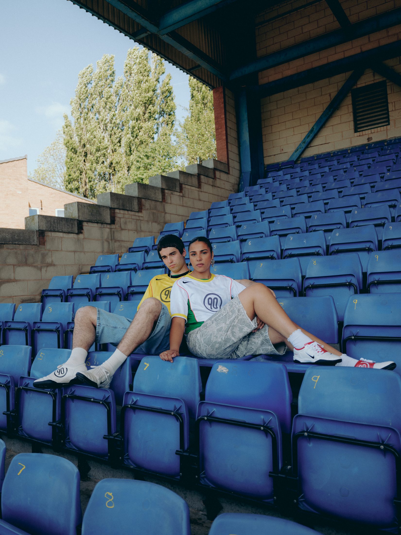 A couple in a football stand wearing Nike T90 football jerseys and Total 90 shoes